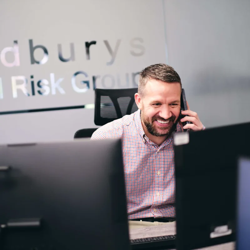 man-smiling-at-desk-answering-calls