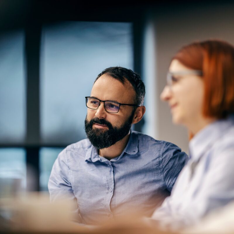 man-with-beard-and-woman-with-red-hair-in-a-meeting